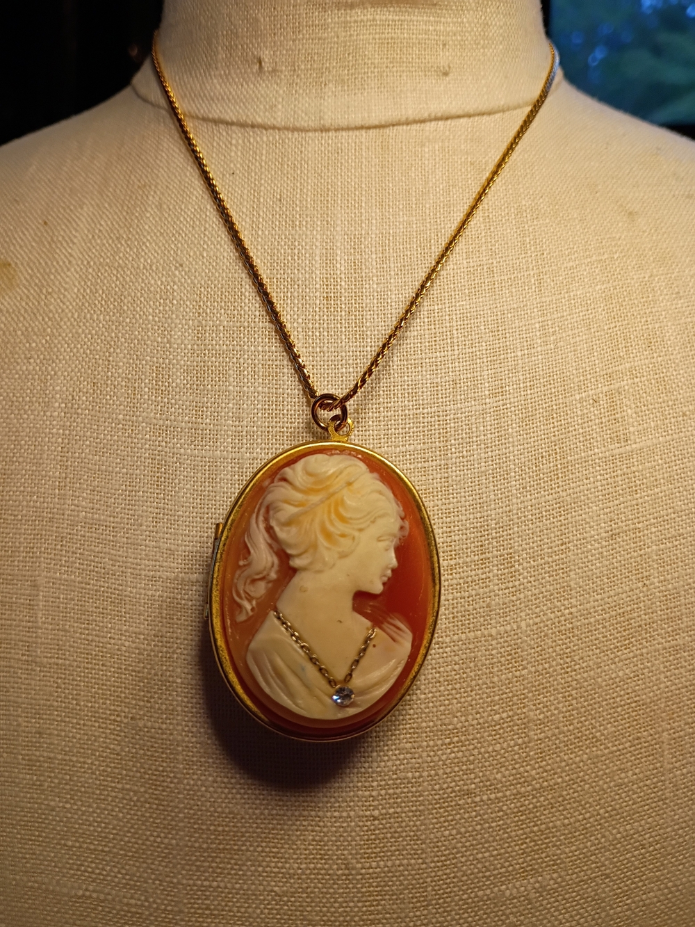 Vintage-style Gold Cameo Locket Pendant Necklace in Cream on Orange